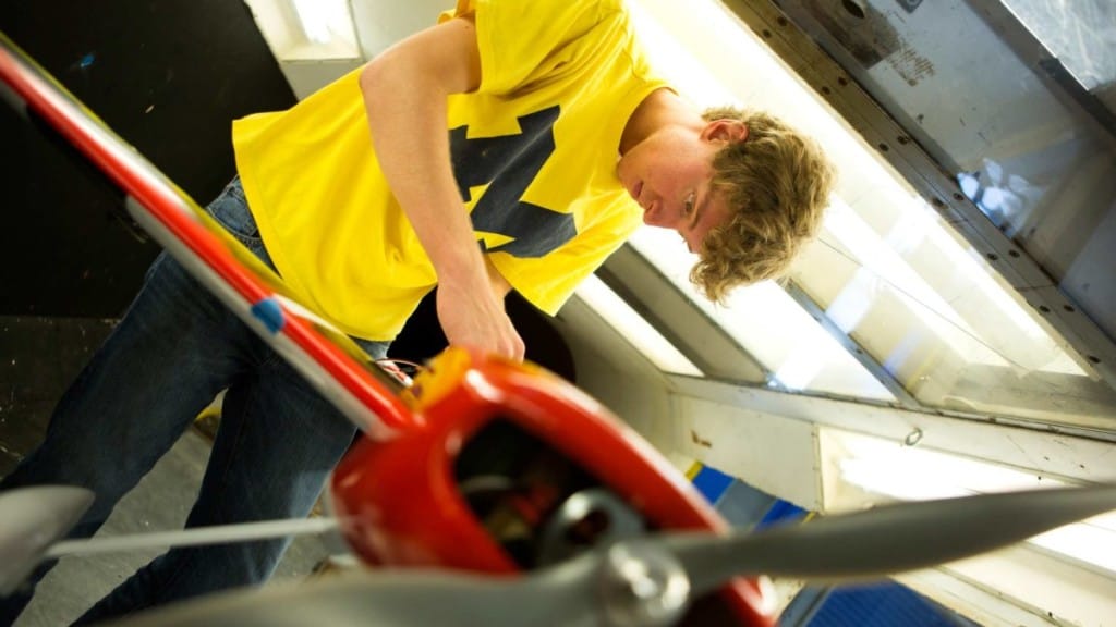 male student adjusts a plane that he is testing
