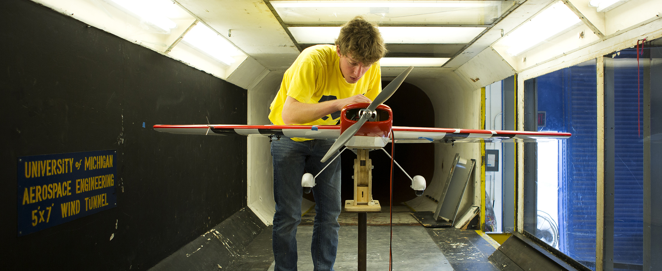 student adjusts a plane that he is testing in the Aerospace Wind Tunnels