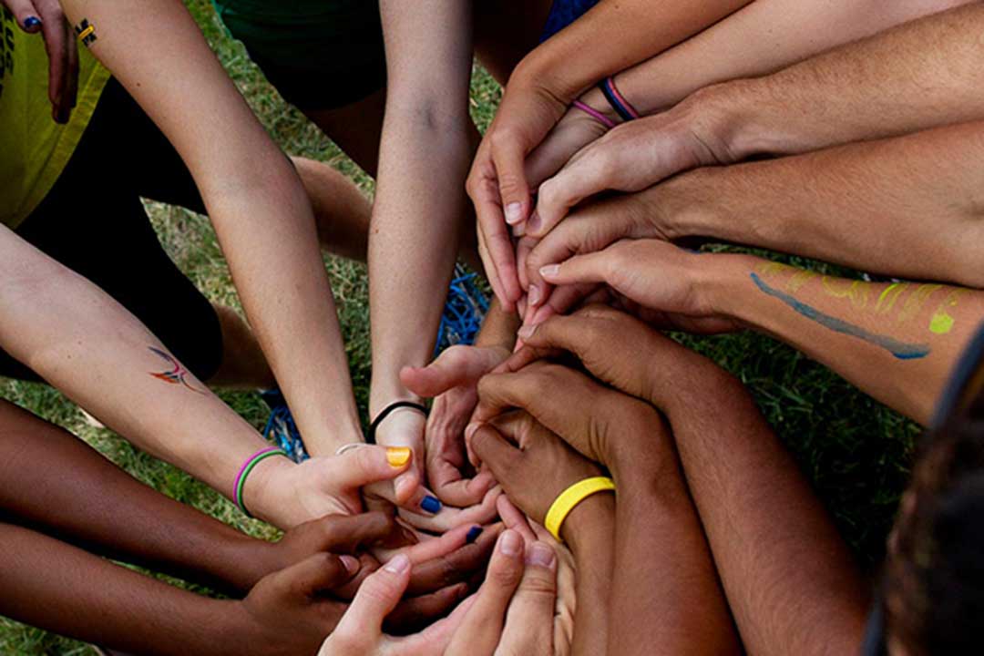 A group of people with their hands together forming a spiral