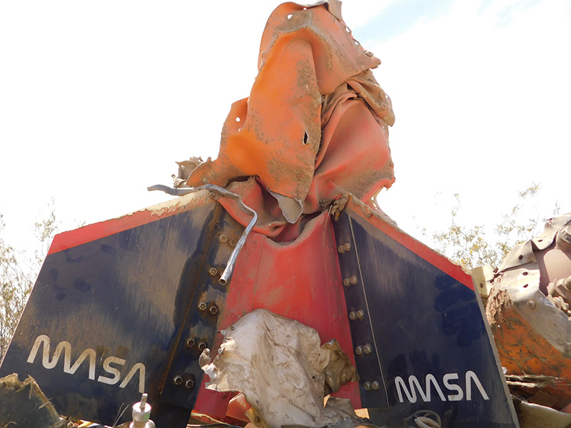 The bottom of the MASA rocket laying destroyed in the desert.