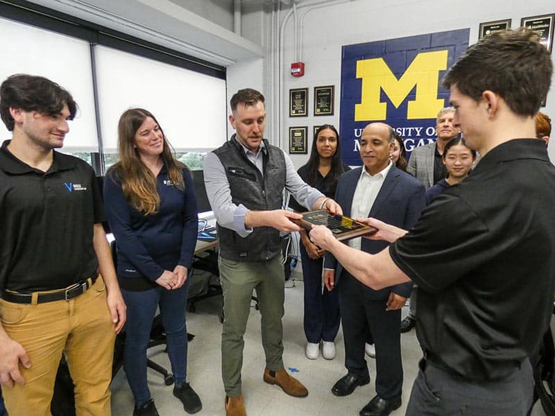 MBSE student hands representatives from Eaton Aerospace honorary plaque
